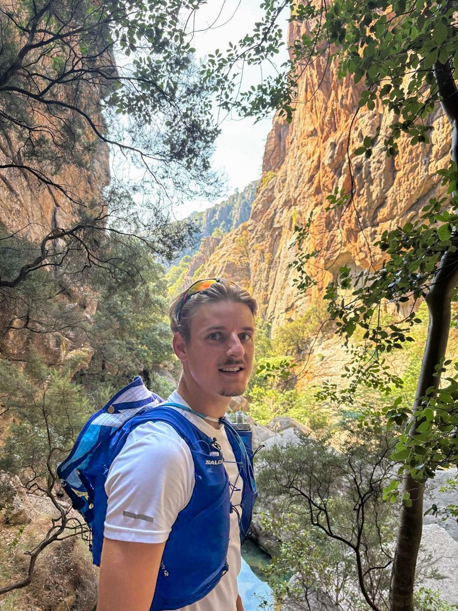 Émile Pauchard en randonnée, dans une gorge rocheuse bordée d’arbres